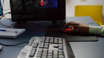 Close up of streamer holding RGB mouse playing space shooter videogame. Pro cyber african woman gaming in home studio for online esports competition on professional powerful computer photo