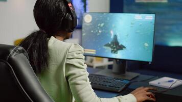 Excited african gamer with headphone winning important online esport competition of space shooter playing on powerful computer. Pro gamer streaming videogames using professional microphone and headset photo