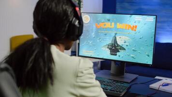 African streamer woman winning space shooter game during esport tournament playing with joystick. Pro gamer using wireless controller, professional mouse and headset at night in streaming home photo