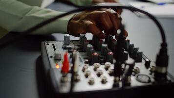 Close up of afro vlogger making sound adjustments while influencer recording social media content with pro equipment. Speaking during livestreaming, blogger discussing in podcast wearing headphones. photo