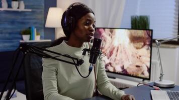Black vlogger speaking with followers on live podcast using microphone wearing headphones. Creative online show On-air production internet broadcast host streaming live content photo