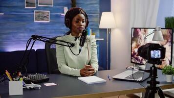 Black blogger sitting at home vlog station while camera recording new podcast. Online show On-air production internet broadcast host streaming live content, recording social media communication photo