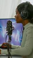 Furious pro afro american gamer talking into microphone for space shooter losing tournament. Streaming viral games for fun using headphones and keyboard for online championship. photo