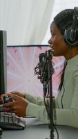Afro american space shooter player happy after winning virtual competiton using RGB powerful computer. Online streaming cyber performing during games tournament in home with neon lights. photo