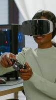 Winner player holding joystick playing videogame in gaming room using virtual reality. Professional pro gamer streaming online videogames with new graphics on powerful computer using modern equipment. photo
