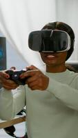 Black videogamer woman winning space shooter game using virtual reality goggles playing games with modern joypad. Professional gamer streaming online videogames with new graphics on powerful computer photo