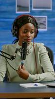 Famous young african woman recording a vlog for subscribers using podcast microphone for vlogging. On-air online production internet broadcast show host streaming live content for social media photo