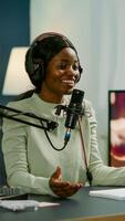 Famous vlogger making online podcast recording for virtual show in front of camera. Influencer using headphones speaking at microphone. On-air production internet broadcast show host streaming photo