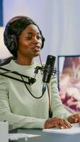 Smiling social media star sitting in front of camera waving and filming for youtube channel using smartphone. Vlogger speaking and recording online talk show at home studio for digital podcast photo