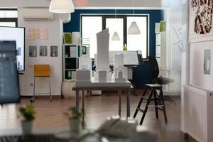Empty workplace for architectural business with equipment as board blueprint paper copybook notepad binder computer. Room with building model maquette for modern design plans. photo