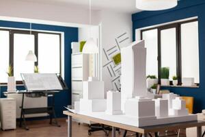 Table with white architectural scale foam model of building complex in empty modern architect office. Urban architecture development project for real estate property. photo