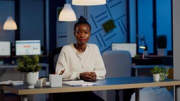 Black manager woman listening partner during conference at midnight from business office planning financial strategy. Lady using modern technology network wireless discussing at virtual meeting photo