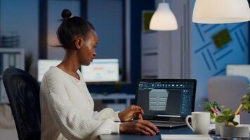 Enthusiastic african engineer analysing cad software to design a 3D concept of container working overtime in start-up company for prototype. Overworked woman studying in office using technology photo
