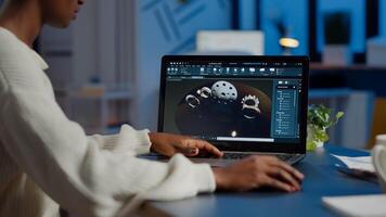 Tired african designer engineer analyzing new prototype of 3D model of industry product, working overtime. Industrial female worker studying gears idea on laptop showing cad software on device display photo