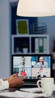 African businesswoman talking during conference with team in midnight using laptop in start up business office. Diverse workers talking during corporate meeting using technology network wireless photo