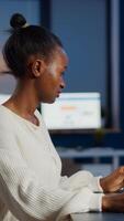 Enthusiastic african engineer analysing cad software to design a 3D concept of container working overtime in start-up company for prototype. Overworked woman studying in office using technology photo