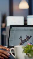 Black woman architect working in modern cad program overtime sitting at desk in start-up business office. Industrial employee studying prototype idea on laptop showing cad software on device display photo