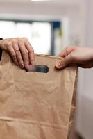 Close up hands of businesswoman in company office taking delivery of fresh food from courier. Employee in business centre recieving restaurant order. Delivery man giving client food order. photo