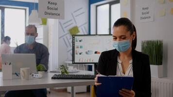 Pov of business woman with medical face mask working at communication project with team during online conference. Entrepreneur on web internet call in new normal corporate space photo