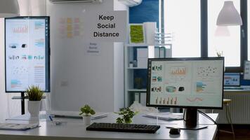 Modern empty office with plastic separators and keep social distance poster on the walls. Empty corporate space business interior with nobody in it photo