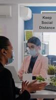 Coworkers wearing medical face masks to prevent infection with coronavirus while working in office company. Business woman talking with her team during online communication meeting photo