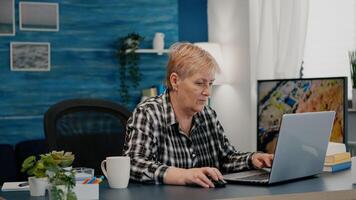 sobrecargado de trabajo mayor mujer trabajando desde hogar a ordenador portátil leyendo escribiendo, buscando analizando Estadísticas para trabajo. cansado antiguo empleado utilizando moderno tecnología mientras retirado marido sentado en sofá foto