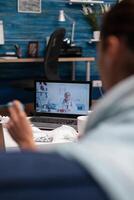 Woman on computer webcam consultation with doctor sitting at home. Young patient with cold flu illness fever temperature virus calling for support medicine diagnostic and medications photo