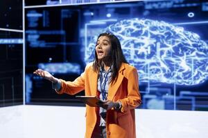 Woman using mic and tablet to do presentation at event bringing together researchers to explore developments in AI and machine learning. Engineer using device artificial intelligence summit speech photo