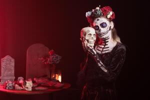 Eerie lady hugging skull at religious processions during Dia de los Muertos november holiday. Woman showing reverence for deceased family members by doing loving gesture towards skull photo