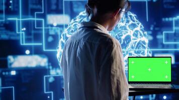 Developer using green screen laptop to implement artificial intelligence parallel processing, breaking up complex computational tasks enabling AI systems to process more input data faster photo