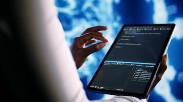 Adept technician programming scripts on tablet, employing AI machine learning. Meticulous employee manipulating lines of code for artificial intelligence applications development, close up photo