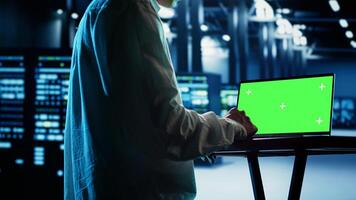 Asian employee using isolated screen laptop to implement artificial intelligence parallel processing. Professional works on chroma key device enabling AI systems to do machine learning inference photo