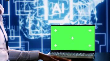 IT executive updating AI systems using green screen laptop, writing intricate binary code scripts. Technical support consultant using programming to upgrade artificial intelligence simulation model photo