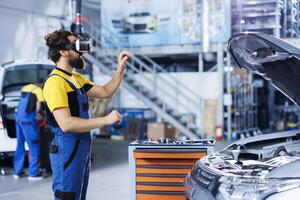 Technician in auto repair shop using virtual reality goggles to visualize car brakes in order to fix them. Licensed garage worker wearing futuristic vr headset while working on malfunctioning vehicle photo