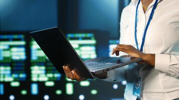 Employee strolling through data center hardware clusters providing processing resources for different workloads. Engineer monitoring blade servers tasked with solving complex operations photo