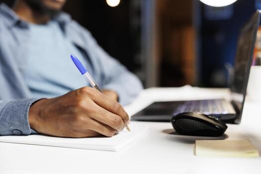 Accounting expert taking notes on files and evaluates reports online, looking into income and expenses elements to create legal monthly balance. Worker calculating capital funds on notebook. photo