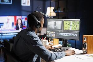 African american editor working on montage with color correction software at home, creating visual effects on videography interface. Media designer editing film segments. photo