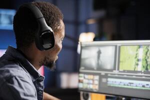 Videographer expert adjusting movie clips on computer, working with color wheel and grading to add visual effects. African american editor making fx montage for post production. photo