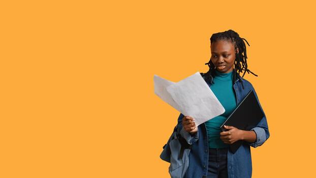 Accounting job employee rolling eyes, looking at report pages, feeling bored, isolated over studio background. Young girl frustrated after reading paperwork all day while solving tasks, camera B photo