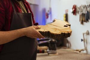 Carpenter doing last touches on piece of wood before using it for furniture assembly, close up shot. Man with injured finger doing woodworking process on lumber block, inspecting for damages photo