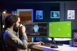 Software developer drinking coffee, watching AI on green screen PC gaining consciousness. Computer scientist consuming hot beverage, seeing artificial intelligence talking on mockup monitor photo