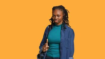 Anxious student at school thinking of raising arm to answer question but unsure of herself, studio background. Teenager lacking confidence needed to volunteer saying explanation to question, camera A photo