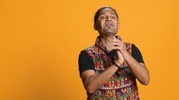 Joyful indian man happily clapping hands, ecstatic about accomplishments. Excited person reacting to good news, cheering, applauding, isolated over studio background, camera A photo