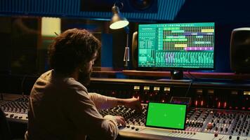 Audio technician working with music recording software and editing tunes, mixing console and control panel board in post production studio. Producer operating technical equipment. Camera B. photo