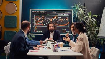 Startup team evaluating infographics data in an executive meeting, corporate restructuring or organizational changes. Adapting the organization to evolving market conditions. Camera B. photo