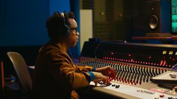 Audio designer leveling sound on a mixer control desk, professional music studio concept. Producer turns up volume and adding effects on a mixing console, recording live tracks. Camera A. photo