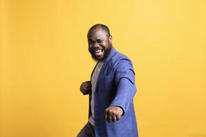 Portrait of showy african american motivational speaker gesturing with hands with determination, isolated over studio background. Expressive vigorous BIPOC lecturer inspiring motivation photo