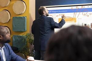 Team of business colleagues examining reports and infographics on interactive board, joining forces to explore essential information for development. Colleagues discussing legal changes. photo