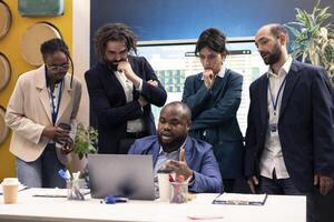 Diverse business colleagues reviewing project details to ensure objectives accomplishment, calculating infographics on laptop and finding ways to increase financial activity. Business management. photo
