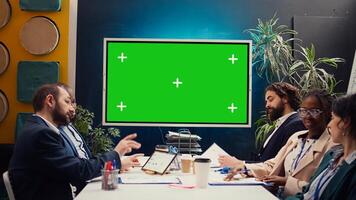 Marketing team meeting in a boardroom with isolated TV display, working together to improve the organization public image and social media presence. Business specialists conduct analysis. Camera B. photo